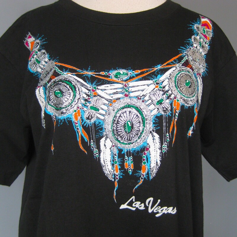 Las Vegas Tee, Black, Size: Large<br />
Fabulous like new high quality tee purchased as a souvneir in Las Vegas, NV in the 90s.<br />
Gorgeous Native American themed design in silver (all the parts of the design that look white in the photos are actually silver), blue and orange.<br />
The back is plain.<br />
Marked size L but will be better for a size medium imo<br />
flat measurements:<br />
shoulder to shoulder: 19<br />
armpit to armpit: 20<br />
width at hem: 21<br />
length: 26<br />
<br />
Like new condition, I don't believe it was ever worn or washed.<br />
<br />
Thanks for looking!<br />
#65795