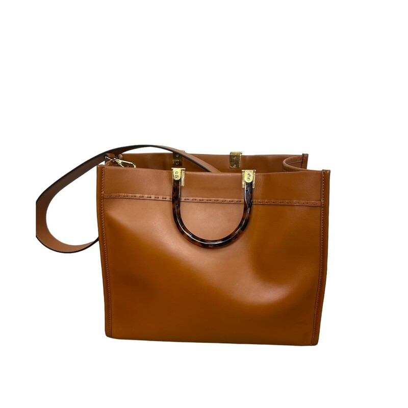 Fendi Sunshine Tote, Brown, Size: Medium<br />
<br />
Dimensions:<br />
Height : 31 cm<br />
Depth : 17 cm<br />
Width : 35 cm<br />
Weight : 1.2 kg<br />
Strap length (min) : 90 cm<br />
Strap length (max) : 90 cm<br />
Shoulder strap drop : 40 cm<br />
<br />
Note: Srtach on front, mark from handles, and light sratches on back.<br />
<br />
Medium Fendi Sunshine bag, a roomy, versatile city shopper distinguished by its linear design and sophisticated details.<br />
Made from brown calfskin with hot-stamped Fendi Roma and stiff plexiglass handles with a tortoiseshell effect.<br />
Features a spacious lined internal compartment, edges in tone-on-tone leather, and gold-finish metalware.<br />
Can be carried by hand or worn on the shoulder thanks to the two handles and detachable shoulder strap.
