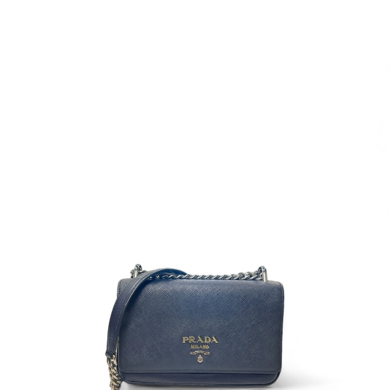 Prada Shoulder Chain, Navy, Size: OS

Dimensions:
Base length: 7.75 in
Height: 5.00 in
Width: 1.75 in
Drop: 12.00 in or 22.00 in

This is an authentic Prada Saffiano Chain Shoulder Bag in Navy. This chic crossbody bag is crafted of smooth calfskin leather in black. The bag features a polished silver chain shoulder strap with a leather shoulder pad, a cross grain front flap, and silver hardware. This flap opens to a partitioned black jacquard fabric interior.