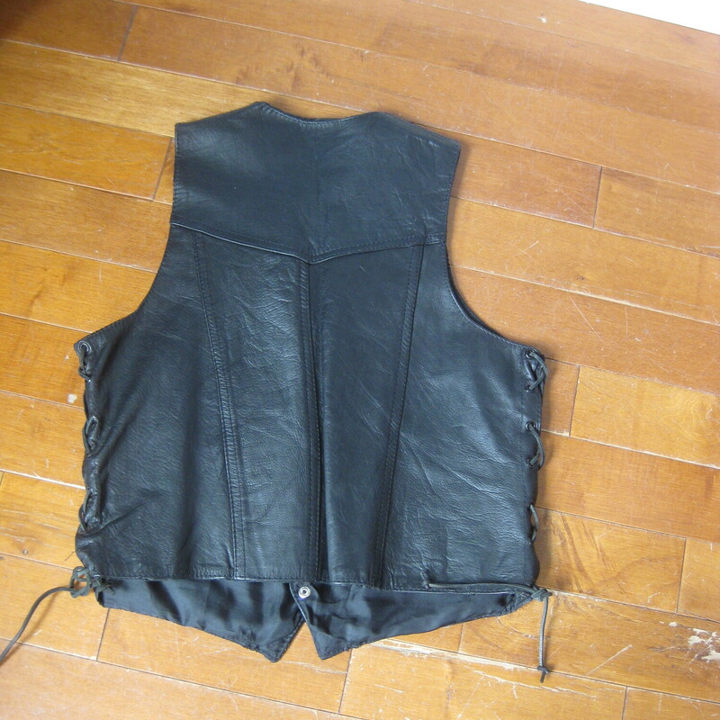 Here's a simple motorcycle vest in black leather. Labeled size medium. The front closes with snaps and the sides are connected with corset lacings so you can adjust the fit to be perfect for you.<br />
<br />
The vest is in great condition, the leather supple and smooth.<br />
Fully lined with two pockets on the front.<br />
For me it was a little oversized even at the minimum adjustments, totally wearable. I am am about 38 B with my bra and a shirt on.<br />
<br />
Here are the flat measurements, please double where appropriate.<br />
Armpit to Armpit: 20 minimum, can be adjusted a few inches larger with the leather thongs at each side.<br />
Length: aprox 23<br />
<br />
thanks for looking!<br />
<br />
#68117