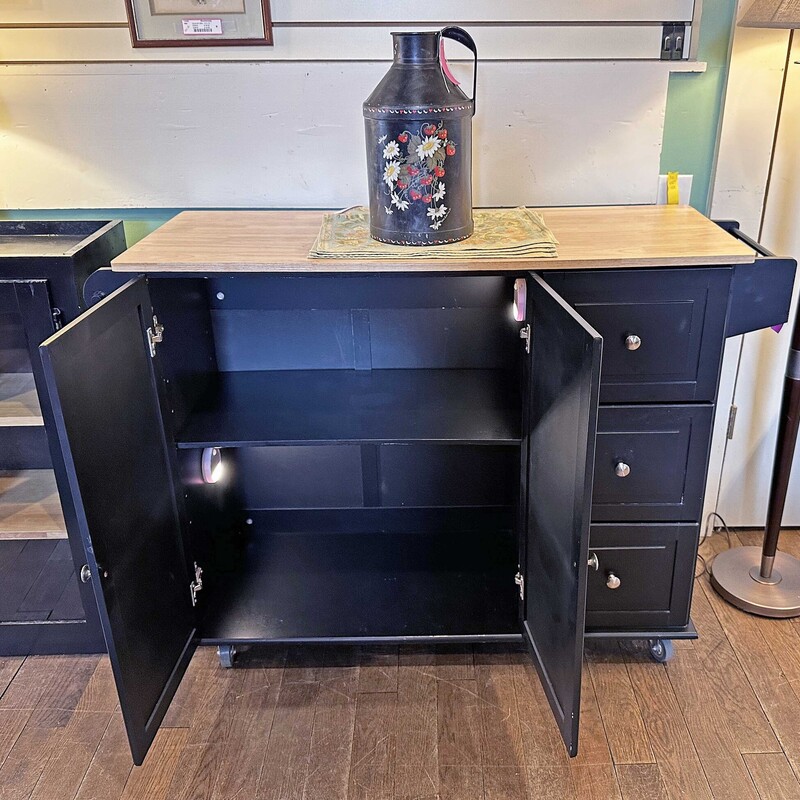 Black/Tan Kitchen Island<br />
50 In L x 18 In W (28 In Opened) x 36 In T<br />
<br />
3 Drawers, 2 Door Cupboard<br />
Casters, Lights Turn On When Opened