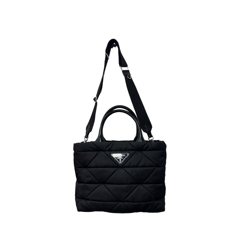 Prada Re-Nylon Padded Tote<br />
<br />
A geometric motif characterizes this quilted tote bag made of Re-Nylon, a fabric produced from recycled and purified plastic materials collected in the ocean. Accented with nappa leather handles and a removable woven tape shoulder strap, the accessory is decorated on the front with the iconic enameled triangle logo.<br />
<br />
Padded triangle motif<br />
Nappa leather handles<br />
Detachable adjustable 85 cm logo-print woven tape shoulder strap<br />
Metal hardware<br />
Enameled metal triangle logo on the front<br />
Zipper closure<br />
Logo-print Re-Nylon lining with three pockets, including one with zipper<br />
Height: 22cm<br />
Width: 28cm<br />
Length: 16cm