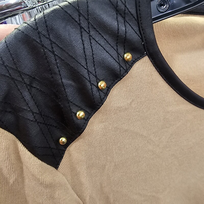 Long sleeve knit top in tan with black faux leather shoulders with studding.