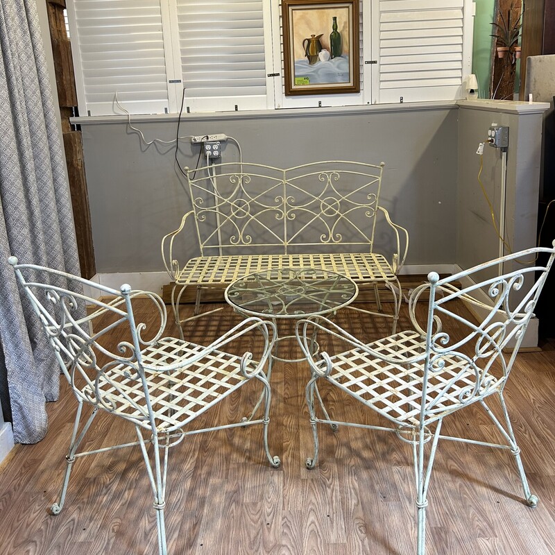 4 Pc. Wrought Iron Patio Set<br />
Love Seat -4 feet long x 2 feet wide x 38 in. tall.<br />
Two chairs - 25 in. from arm to arm x 37 in. tall in back<br />
Seat measures 20 in. long x 19 in. wide.<br />
Glass top table measures 23 in. round x 22 in. tall<br />
<br />
Gorgeous, heavy  wrought iron patio set is solid! This has some wear but it has not changed the quality of this set. It can easily be spray painted any color that you wish.<br />
The glass on round table is thick and is not attached.