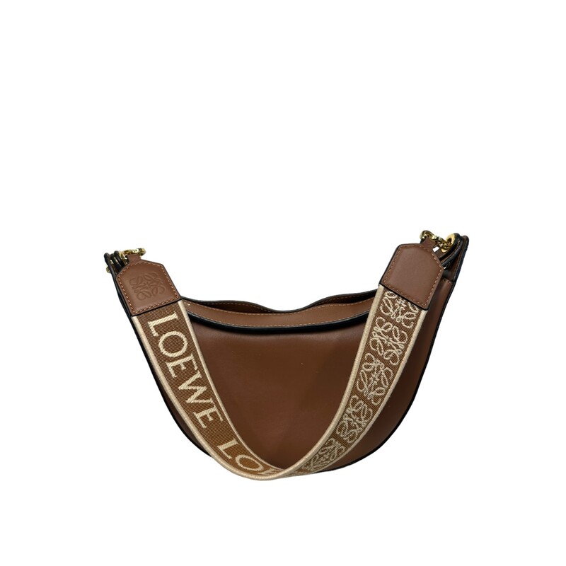 Loewe Jaquard Luna, Pecan, Size: OS

Dimensions:
Min. Strap Length: 45cm / 17.7in
Handle Drop: 28cm / 11in
Depth: 6cm / 2.4in
Max. Strap Length: 45cm / 17.7in
Height: 13cm / 5.1in
Width: 25cm / 9.8in

Loewe named this bag 'Luna' for its sculptural crescent shape. It's crafted from smooth leather and is fitted with customizable sliding eyelets, so you can either add a charm or swap out the branded jacquard strap for the simple leather handle.