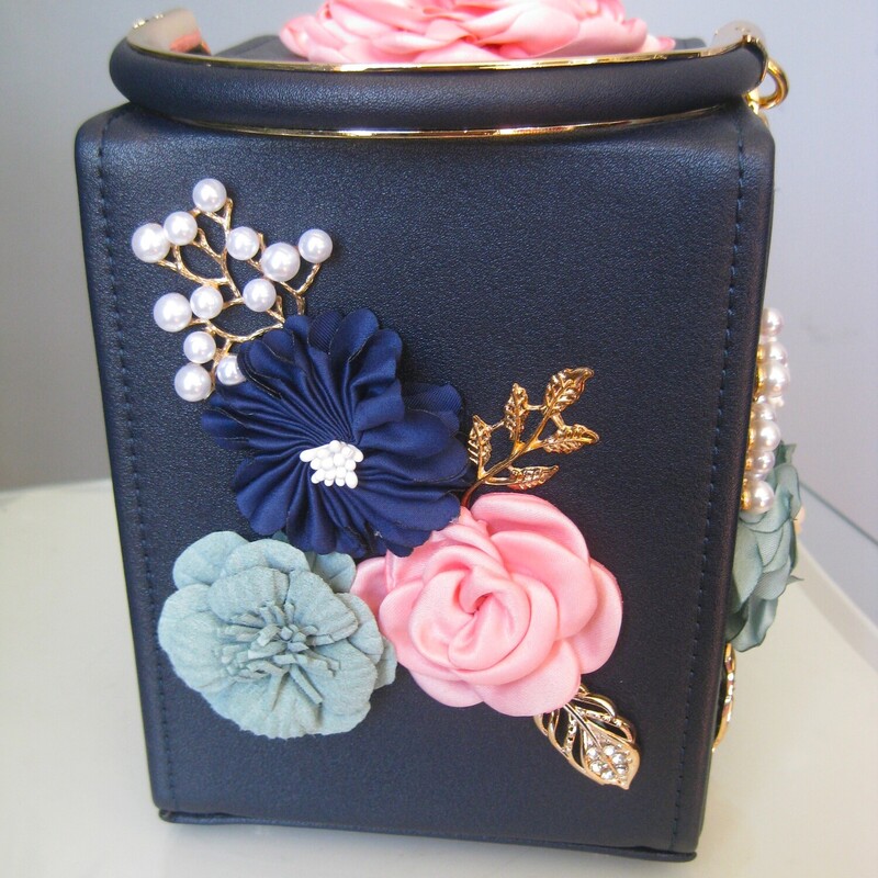How pretty will this little bag look on the table at your next even?<br />
It's a navy blue firm body box bag with pink and blue fabric flowers on the sides and the top.<br />
Sturdy handle with gold accents and a removeable chain strap threaded with faux leather<br />
Measurements:<br />
width: 4.75 height: 6 3/8 depth: 6<br />
Handle drop: 3.5<br />
Strap drop: 20 (crossbody strap can be removed)<br />
<br />
Perfect condition!<br />
thanks for looking!<br />
#71462