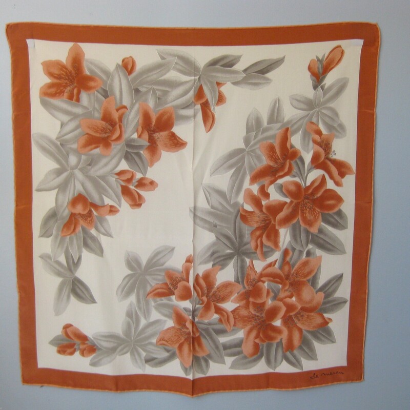 Very pretty square silk scarf in soft tannish orange and gray. cream center and touches of black<br />
The floral pattern features large scale lillies.<br />
Hand rolled edge<br />
it's signed, but I cannot make out the letters! Milren? Please help if you know, I would really appreciate!<br />
<br />
30 x30<br />
<br />
Thanks for looking!<br />
#65691