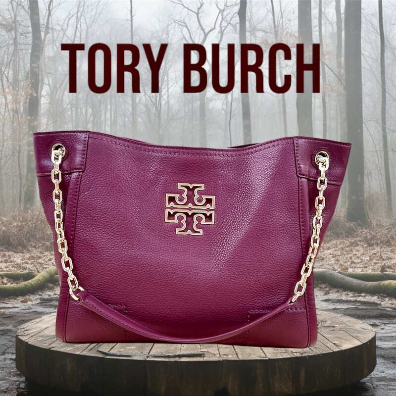 TORY BURCH<br />
Defined by a clean, versatile shape punctuated with a cut-out double-T logo, our new Britten Small Slouchy Tote is made of soft pebbled leather with chain-adorned straps. The roomy interior has multiple pockets, including a convenient center zip compartment that can fit a phone and a wallet. It’s graphic and polished, a great style for work or weekend.<br />
<br />
* Holds a 10\" tablet, a continental wallet, a notebook, sunglasses, an iPhone 6 Plus, a makeup compact and a lip color<br />
* Pebbled leather<br />
* Magnetic snap closure<br />
* Flat leather-and-chain double straps with 8.76\" (22 cm) drop when doubled<br />
* 1 interior center zipper compartment, 1 zipper pocket at back wall<br />
* Height: 9.56\" (24 cm)<br />
* Length: 11.75\" (29.5 cm)<br />
* Depth: 4.78\" (12 cm)<br />
This Handbag is in like new condition, with no marks, flaws or stains.  Absolutely Beautiful!<br />
Original Retail Price:  $475.00