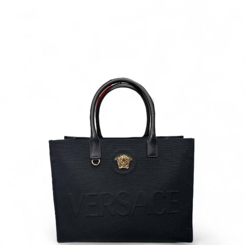 Versace Le Medusa
 Size: 0S

La Medusa Canvas Large Tote Bag image number 5 Black+Gold Versace
La Medusa Canvas Large Tote Bag image number 6 Black+Gold Versace
LA MEDUSA CANVAS LARGE TOTE BAG
$1,595
COLOR: Black+Gold

msg.assistive.selected.text

Shop now. Pay with Klarna. Learn more

Crafted in tonal canvas with leather top handles, this classic tote bag is adorned with a Medusa plaque and raised Versace logo lettering. The roomy interior has a large zipped pocket and protector strap. Attach a Versace bag charm with the D-ring for an added touch of style.

La Medusa hardware
Raised logo lettering
Double top handles with internal protector strap
Internal zipped pocket
Outer fabric: 100% Cotton
Lining: 100% Cotton
Trim: 100% Calf leather