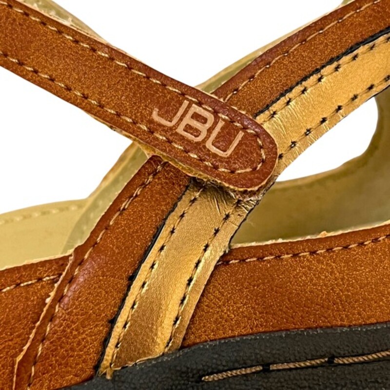 New JBU Dove Sandals<br />
Textile and synthetic upper with airy cutout detailing.<br />
Adjustable hook-and-loop closure.<br />
T-strap to ensure a snug fit.<br />
Memory foam footbed for added comfort.<br />
Awarded Seal of Acceptance by APMA for promoting good foot health.<br />
Brown, Copper, and Tan<br />
Size: 10