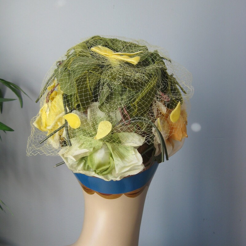 Here is a pill box hat made out of a green flexible plastic cage covered with yellow fabric flower and green fabric leaves.<br />
It measures just 18 around at the opening, but since the cage or frame is flexible you can push it down on whatever part of the head you wish and then pin it in place to keep it there.<br />
no labels<br />
excellent vintage condition, no flaws<br />
<br />
thanks for looking!<br />
#72873
