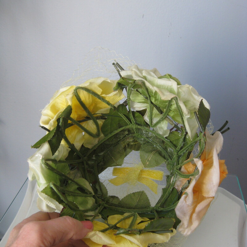 Here is a pill box hat made out of a green flexible plastic cage covered with yellow fabric flower and green fabric leaves.<br />
It measures just 18 around at the opening, but since the cage or frame is flexible you can push it down on whatever part of the head you wish and then pin it in place to keep it there.<br />
no labels<br />
excellent vintage condition, no flaws<br />
<br />
thanks for looking!<br />
#72873