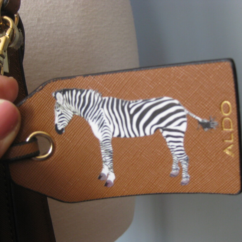 NWOT Aldo Zebra Xbody, Brown, Size: None<br />
Super cute brown faux leather shoulder crossbody bag by<br />
Aldo<br />
features appliques on the front flap of a big zebra, flowers and jewels.<br />
inside are two main compartments with one zippered pockets and three slips, and one penholder.<br />
Never used, the gold hardware still has its plastic protedtive films\\<br />
Adjustable strap<br />
10.25 x 8.25 x 3.25<br />
strap drop as shown: 22.5<br />
<br />
thanks for looking!<br />
#67004