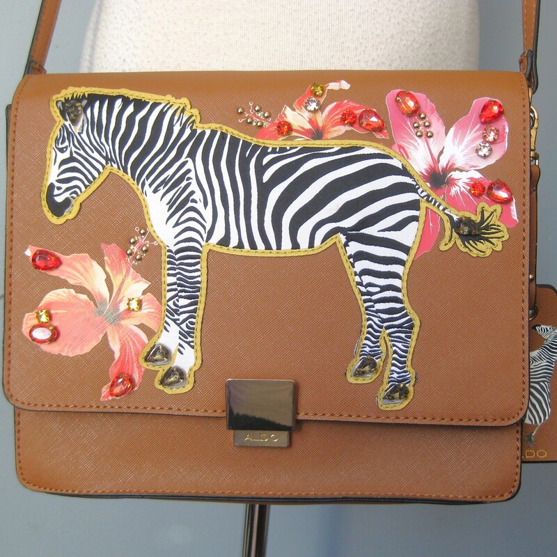 NWOT Aldo Zebra Xbody, Brown, Size: None<br />
Super cute brown faux leather shoulder crossbody bag by<br />
Aldo<br />
features appliques on the front flap of a big zebra, flowers and jewels.<br />
inside are two main compartments with one zippered pockets and three slips, and one penholder.<br />
Never used, the gold hardware still has its plastic protedtive films\\<br />
Adjustable strap<br />
10.25 x 8.25 x 3.25<br />
strap drop as shown: 22.5<br />
<br />
thanks for looking!<br />
#67004