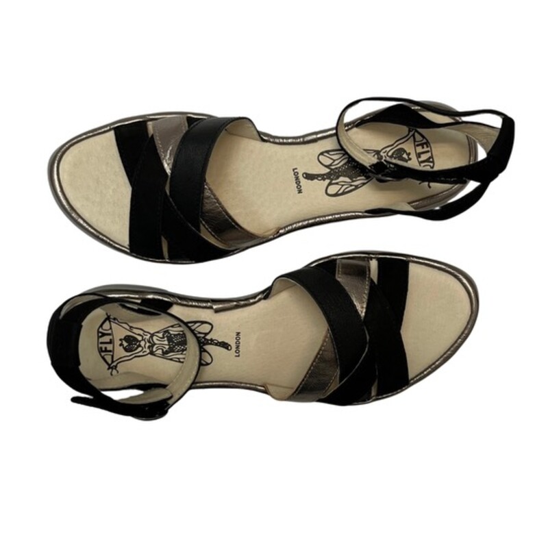 New Fly London CUNE Sandals<br />
Ground control. This low-heeled sandal keeps pace with your busy flight patterns this summer! From FLY London.<br />
Multi-strap upper, hook-and-loop closure on ankle strap<br />
Padded insole<br />
Approximately 3/4H sole<br />
Fit: true to size<br />
Leather upper; man-made balance<br />
Contains latex<br />
Color: Black and Gold<br />
Size: 8.5