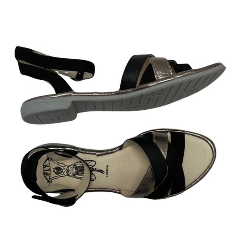 New Fly London CUNE Sandals<br />
Ground control. This low-heeled sandal keeps pace with your busy flight patterns this summer! From FLY London.<br />
Multi-strap upper, hook-and-loop closure on ankle strap<br />
Padded insole<br />
Approximately 3/4H sole<br />
Fit: true to size<br />
Leather upper; man-made balance<br />
Contains latex<br />
Color: Black and Gold<br />
Size: 8.5