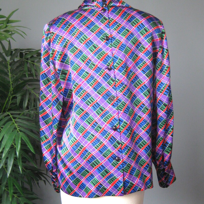 Colorful Julie Fran silk jacquard blouse.<br />
This blouse features an abstract geometric grid like print in purple, blue, green, red, white and black.<br />
It has big shoulder pads, a cowl neckline<br />
It buttons in the back and the sleeves have a fairly long cuff with the same black buttons.<br />
Made in Korea<br />
Marked size 10, here are the flat measurements:<br />
shoulder to shoulder: 16<br />
armpit to armpit:  21<br />
width at hem: 22<br />
length: 24<br />
underarm sleeve seam: 17.75<br />
excellent condition, no flaws.<br />
<br />
Thanks for looking!<br />
#72842