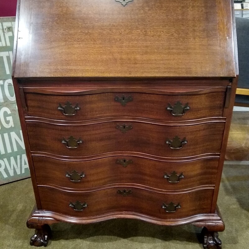 Mahogany Secretary Desk

Mahogany Secretary Desk in good condition.  Front of desk has 4 serpentine style drawers.  Top drops down and inside is 4 small drawers with 6 cubbies and 1 middle door that opens.  Very nice piece!
