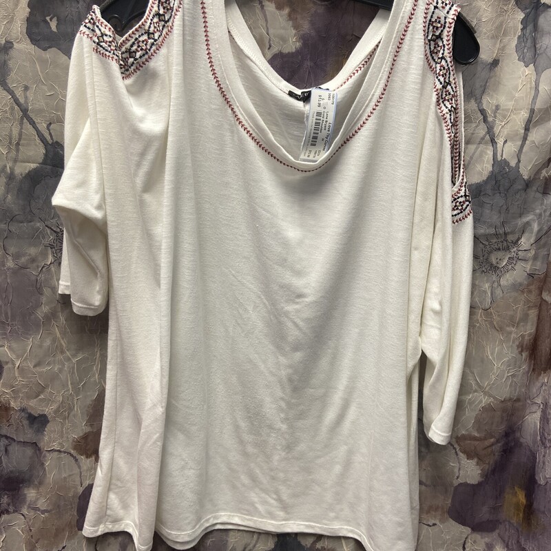 Half sleeve knit top in white with cold shoulder design and embroidered pattern on shoulders and neckline.