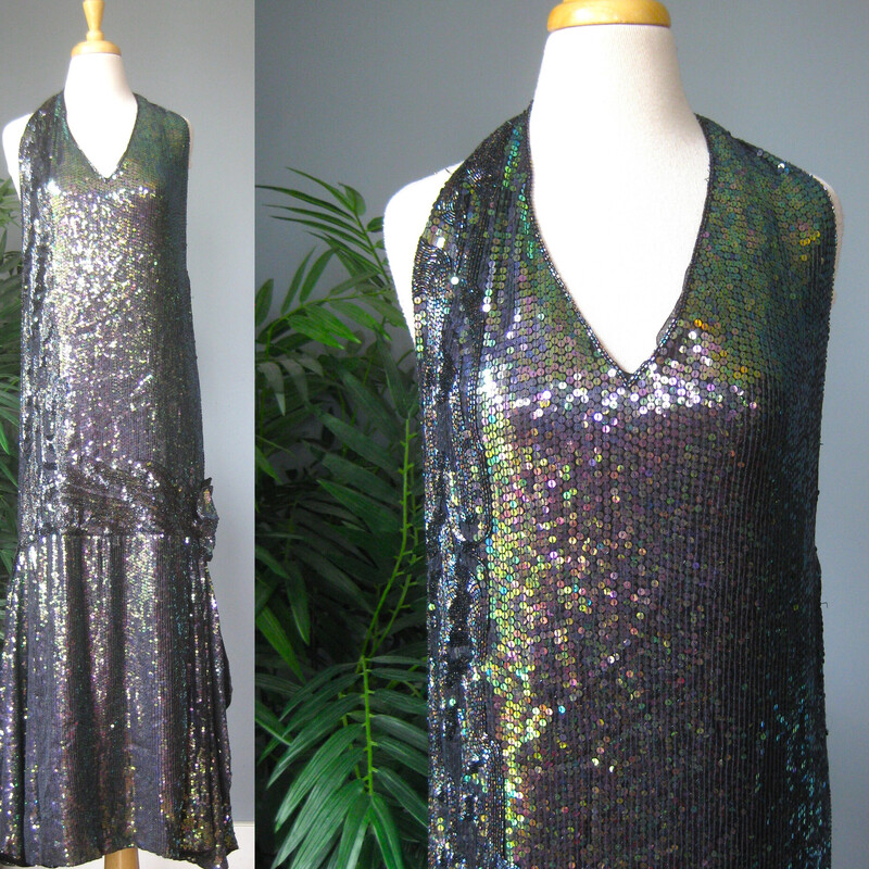 Vtg Scarlet Q Beaded Halt, Multi, Size: Large
fabulous sequined halter gown in the style of the 1920s in the colors of a dark mermaid.
The dress has a straight dropped waist silhouette with a gather and slit at one side embellished with a sequined flower.
the halter neck has two strong hook and eyes and those are the only closures.
The beaded layer is silk and it's fully lined in rayon.
This dress would be so perfect for a Great Gatsby themed formal event.

It's in perfect condition but the fit must be given some careful consideration.
I tried it on, I am size 8-10, 136lbs, 5'5, 38-30-41
It was too long in the bodice for me. a little too big in the cup area
Also too tight in the hips and seat.
but too big in the waist.
The open back has a straight across top edge, it's a little gathered but doesnt really hug the body.

Here are the flat measurements:
armpit to armpit: 18
waist area: 19
hip: 20
length from the back of the neck to the hem: 58

It might need some work by your seamstress to tailor it perfectly for you.
Get in touch if I can help with figuring out the fit for you.

Thanks for looking!
#72761