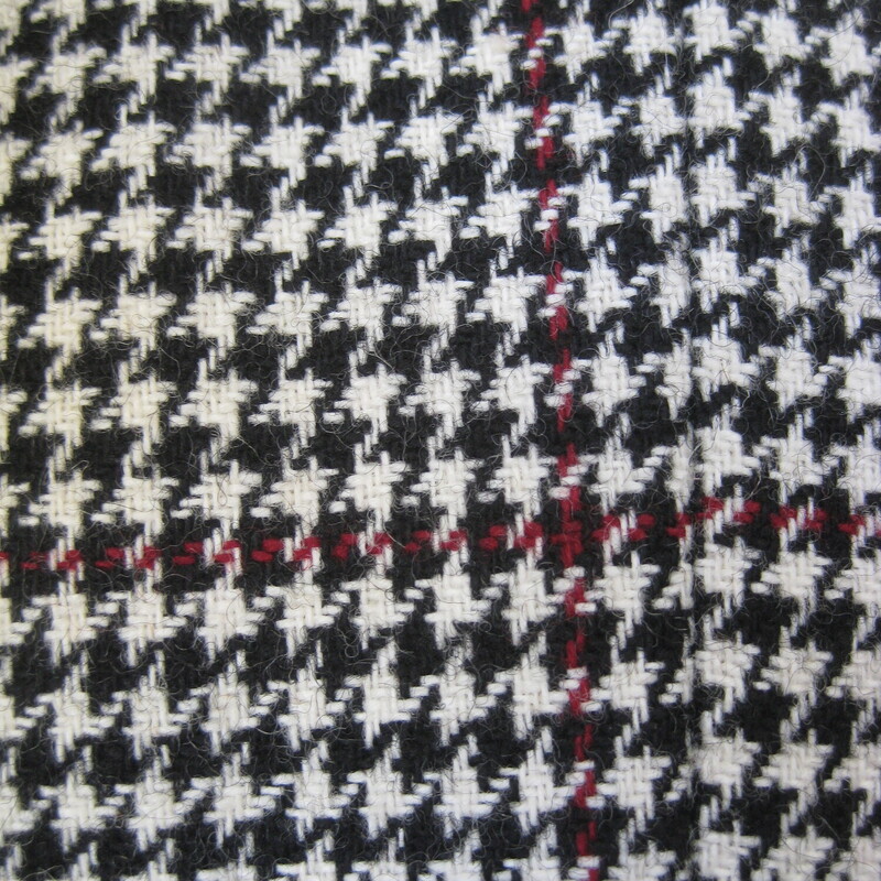 Unique wool coat in a black and white houndstooth check with a red stripe.<br />
The coat has a fit and flare silhouette, close at the top and a full skirt.<br />
It also has a dramatic collar and closure arrangment.<br />
big patch pockets, useful and stylish.<br />
It closes with black plastic buttons<br />
fully lined<br />
union label<br />
<br />
Excellent condition, old but no flaws.<br />
Here are the flat measurements, please double where appropriate:<br />
Shoulder to shoulder: 17<br />
armpit to armpit: 19.5 (measured on the inside of the coat)<br />
waist: 17 (also measured on the inside)<br />
hips: 21.5<br />
underarm sleeve seam length: 17.25<br />
overall length: 39<br />
<br />
thanks for looking!<br />
#70406