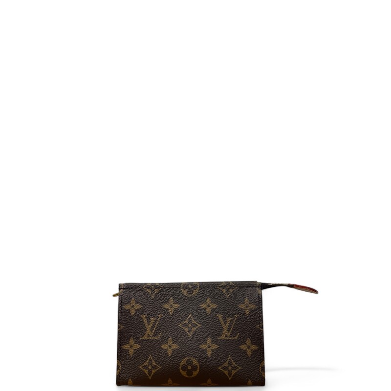 LOUIS VUITTON Monogram Toiletry Pouch 15. This cosmetics pouch is crafted of classic Louis Vuitton monogram coated canvas in brown. The pouch features a gold top zipper that opens to a dark pink leather-like interior.
Dimensions:

Length: 5.75 in
Height: 4 in
Width: 2 in