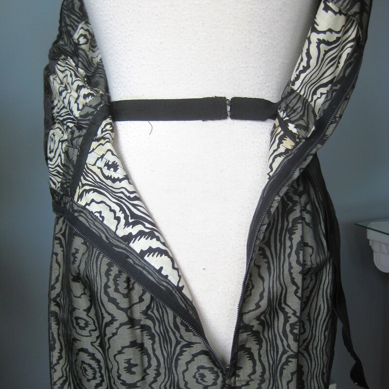 Vtg 50s Silk Print, Blk/gray, Size: Small<br />
Sophisticated cocktail dress from the 1950s.  This is a custom handmade dress.<br />
It was made from a black and white abstract swirl print cotton or cotton silk blend overlain with sheer black organza.  Fitted and offering high end dressmaker details like a waist and bra bra stays and bound armholes.  It also has a deep hem, 4 1/8, this deep hem provides stability and a bit of weight at the bottom, not that this dress is liable to fly up in any wind, it's too fitted for that!<br />
<br />
Center back black metal zipper.<br />
beautifully fringed attached satin belt.<br />
<br />
This dress fits my size 4 mannequin perfectly but without a lot of room to spare.<br />
Here are the flat meausurements:<br />
armpit to armpit: 18.5<br />
waist: 13<br />
hip: 18.75<br />
length: 38<br />
<br />
Excellent condition, no flaws.<br />
thanks for looking!<br />
#70432