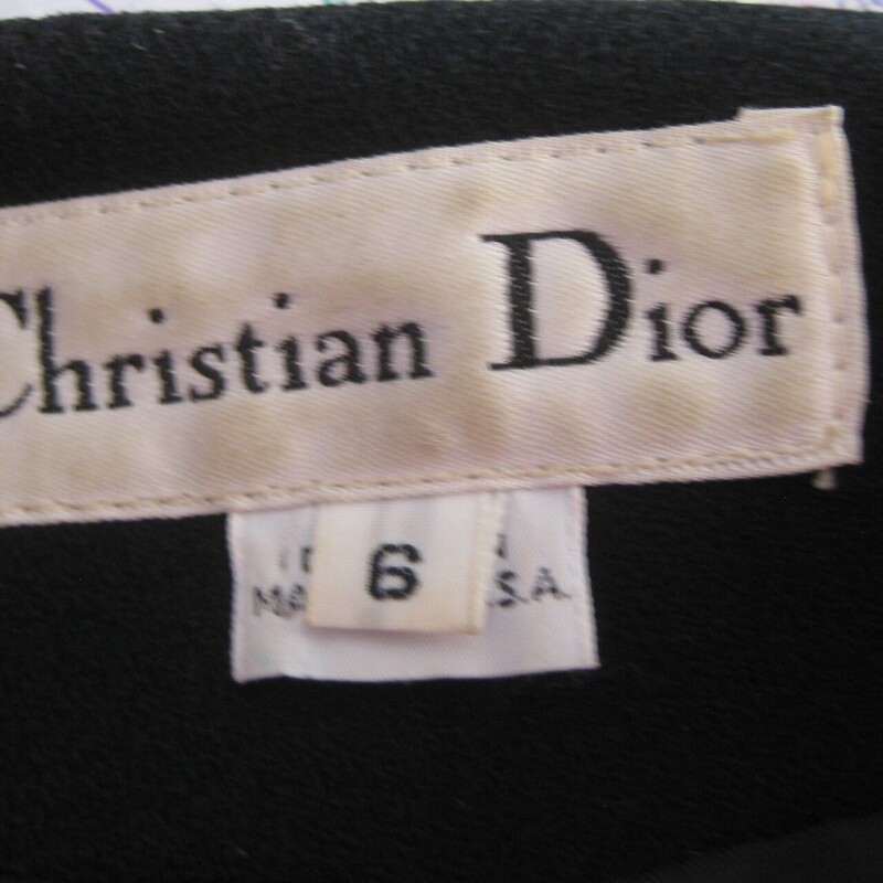 Stunning Christian Dior Blazer in black wool<br />
This blazer is a bit long as was the style in its day.<br />
Such clean lines and beautiful tailoring.<br />
One button at the neck and the rest are hidden in the placket.<br />
Fully lined in black.<br />
When I got it it has a rip in the lining at each shoulder area. I had it repaired, you can see the repairs in my last photo.<br />
Marked size 6<br />
shoulder to shoulder: 16.5<br />
armpit to armpit: 19.75<br />
waist: 17<br />
underarm sleeve seam: 16.75<br />
length: 32<br />
<br />
thanks for looking!<br />
#72706