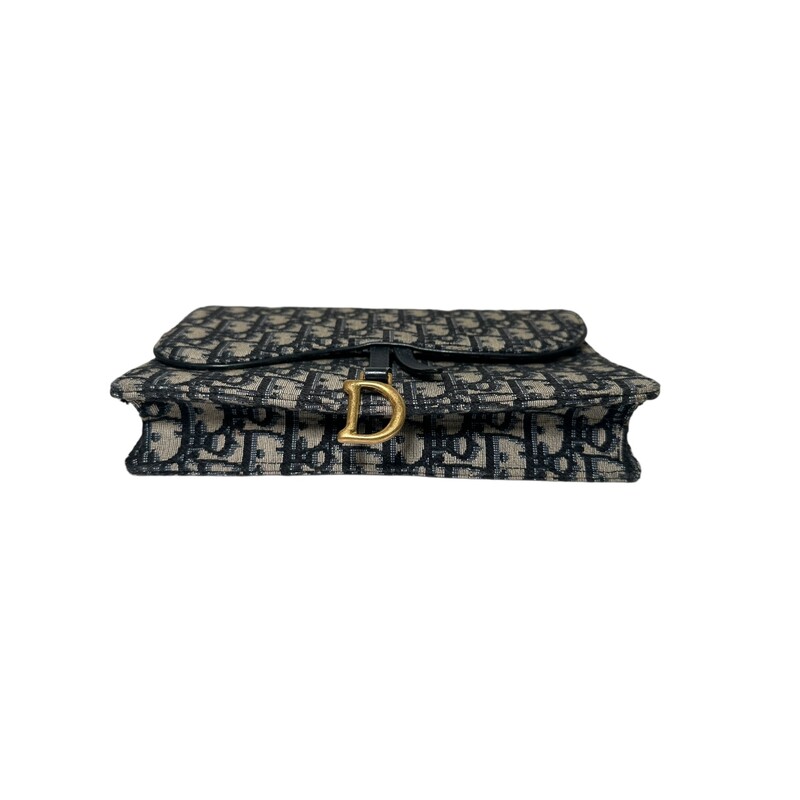 CHRISTIAN DIOR Oblique Saddle Chain Wallet in Blue. This wallet is crafted of blue on beige Dior monogram canvas. The wallet features a saddle-style crossover flap with a brass Dior D charm and a matching optional chain-link shoulder strap. The bag opens to a matching leather interior with card slots.

Dimensions: 21.5 x 12.5 x 4.5 cm / 8.5 x 5 x 2 inches (Length x Height x Width)
Chain length: 46.5 inches
Chain drop length: 22.5 inches