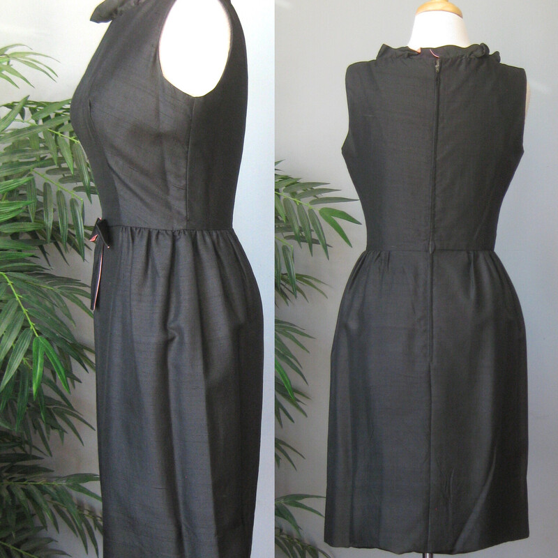 Simple black silk sheath dress from the 1950s with a VERY cute twist and a Jackie Kennedy vibe.<br />
Fitted at the waist with a darling bow and a relaxed ruffled high neck. The bow and the neckline are lined with baby pink.<br />
<br />
No fabric or band id tags. But almost certainly silk shantung.<br />
unlined<br />
Center back metal zipper<br />
<br />
marked size 11, but disregard that number! vintage sizes have nothing to do with modern sizes.<br />
This dress fits my size 4 mannequin well.<br />
Pls use flat measurements below:<br />
Armpit to Armpit: 19.5<br />
Waist: 13.25<br />
Hips: 19.5<br />
Overall Length: 37 - it is unlined and the hem is deep. You can easily change the hem to make it shorter BUT!! the fabric turned under for the current hem has some significant discoloration due to being stored on a hanger and inside out for many years before I bought it. So you can make it shorter if you like but probably not longer.<br />
<br />
Thank you for looking<br />
#70443