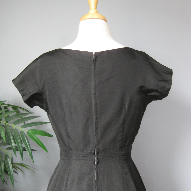 Simple black silk sheath dress from the 1950s
No tags.
unlined
Center back metal zipper
Perfect wardrobe builder, this classic little black dress will easily take you from work to evening to weekend by changing up the shoes and jewelry..

NO size tags, fits my size 4 mannequin well.
Pls use flat measurements below:
Armpit to Armpit: 18.5
Waist: 14
Hips: 19
Overall Length: 40

Thank you for looking
#70431