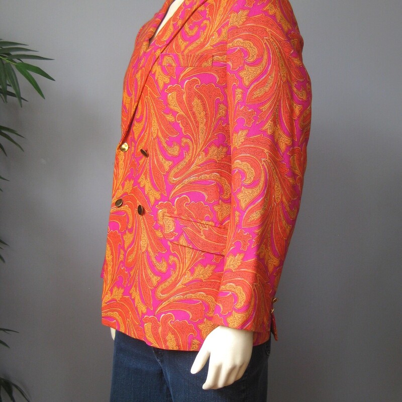 For Cool Girls or Guys<br />
This blazer was made in 1966 for an American serviceman stationed in Japan.<br />
Fabulous orange and magenta paisleyy fabric, which feels like a substantial woven cotton.<br />
Beautifully tailored with interior pockets, a little bit of padding at the upper back and lovely touches, like the finish on the exterior pockets.<br />
It's furnished with flat gold buttons and there is a spare of each type (one of rhte cuffs and one for the front closures) on the inside.<br />
It's double breasted with two flaps at the back and high peaked lapels<br />
The man it was made for was not a big man. My mannequin is about a modern mens size medium and it is a little snug on him.<br />
This jacket would work for a woman or a man. I am 5' 5, about a modern size 8 on top and it is only a smidge too big for me. I would totally wear it.<br />
<br />
No size tag, here are the Flat Measurements:<br />
<br />
Armpit to Armpit: 20.25, measured on the inside<br />
Length (back of neck to hem): 29.75<br />
waist area: 18.5<br />
Length of underarm sleeve seam: just under 18<br />
Width at hem area while lying flat and buttoned: 19<br />
Length: 31<br />
Any questions about fit? please get in touch I can help!<br />
<br />
Excellent condition! No flaws.<br />
<br />
Thank you for looking.<br />
#75098