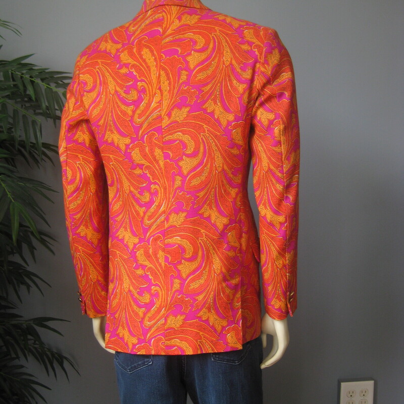 For Cool Girls or Guys<br />
This blazer was made in 1966 for an American serviceman stationed in Japan.<br />
Fabulous orange and magenta paisleyy fabric, which feels like a substantial woven cotton.<br />
Beautifully tailored with interior pockets, a little bit of padding at the upper back and lovely touches, like the finish on the exterior pockets.<br />
It's furnished with flat gold buttons and there is a spare of each type (one of rhte cuffs and one for the front closures) on the inside.<br />
It's double breasted with two flaps at the back and high peaked lapels<br />
The man it was made for was not a big man. My mannequin is about a modern mens size medium and it is a little snug on him.<br />
This jacket would work for a woman or a man. I am 5' 5, about a modern size 8 on top and it is only a smidge too big for me. I would totally wear it.<br />
<br />
No size tag, here are the Flat Measurements:<br />
<br />
Armpit to Armpit: 20.25, measured on the inside<br />
Length (back of neck to hem): 29.75<br />
waist area: 18.5<br />
Length of underarm sleeve seam: just under 18<br />
Width at hem area while lying flat and buttoned: 19<br />
Length: 31<br />
Any questions about fit? please get in touch I can help!<br />
<br />
Excellent condition! No flaws.<br />
<br />
Thank you for looking.<br />
#75098