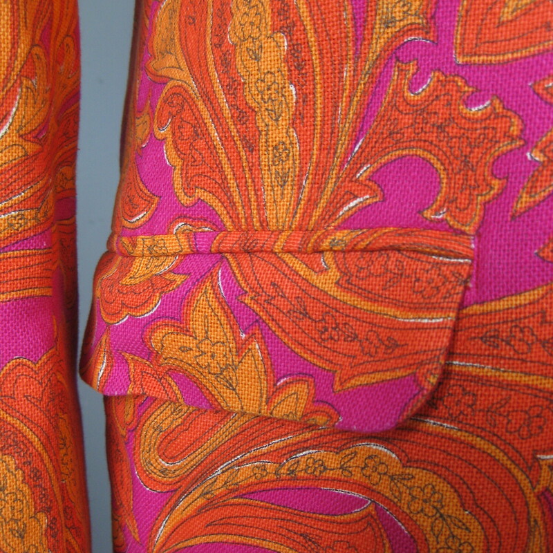 For Cool Girls or Guys<br />
This blazer was made in 1966 for an American serviceman stationed in Japan.<br />
Fabulous orange and magenta paisleyy fabric, which feels like a substantial woven cotton.<br />
Beautifully tailored with interior pockets, a little bit of padding at the upper back and lovely touches, like the finish on the exterior pockets.<br />
It's furnished with flat gold buttons and there is a spare of each type (one of rhte cuffs and one for the front closures) on the inside.<br />
It's double breasted with two flaps at the back and high peaked lapels<br />
The man it was made for was not a big man. My mannequin is about a modern mens size medium and it is a little snug on him.<br />
This jacket would work for a woman or a man. I am 5' 5, about a modern size 8 on top and it is only a smidge too big for me. I would totally wear it.<br />
<br />
No size tag, here are the Flat Measurements:<br />
<br />
Armpit to Armpit: 20.25, measured on the inside<br />
Length (back of neck to hem): 29.75<br />
waist area: 18.5<br />
Length of underarm sleeve seam: just under 18<br />
Width at hem area while lying flat and buttoned: 19<br />
Length: 31<br />
Any questions about fit? please get in touch I can help!<br />
<br />
Excellent condition! No flaws.<br />
<br />
Thank you for looking.<br />
#75098