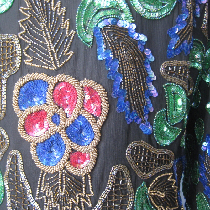 This is a very cool sequined jacket from the 1990s by
Lisiano
it's a little boxy and cropped
substantial
The beaded shell is silk and the lining is rayon
fully lined with shoulder pads.
single hook and eye closure at the neck
gorgeous green red and blue florals with gold accent beading
This jacket is unusded and comes with a small bag of extra beads and sequins
Design covers front and back and sleeves
Made in India
Marked size 10, should fit a modern size small or smaller medium size gal.  I think best for a petite as the length of the jacket and the sleeves is a little smaller than average

interior flat measurements:
shoulder to shoulder: 16
armpit to armpit: 19
length: 19.25
width at hem: 16
underarm sleeve seam length: 15.5
Excellent condition, no flaws
thanks for looking!
#71712