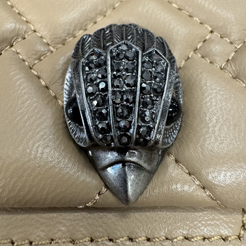 Kurt Geiger Kensington Handbag<br />
Quilted with Chain Strap<br />
2 Magnetic Snap Closures and Interior Wall Pocket<br />
Eagle Head Jewel Detail for Closure<br />
100% Leather<br />
Color: Warm Beige