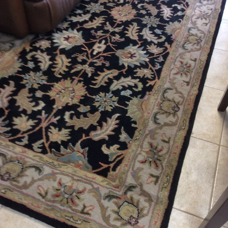 This 5x7, wool Area Rug has a black field with multicolor floral designs