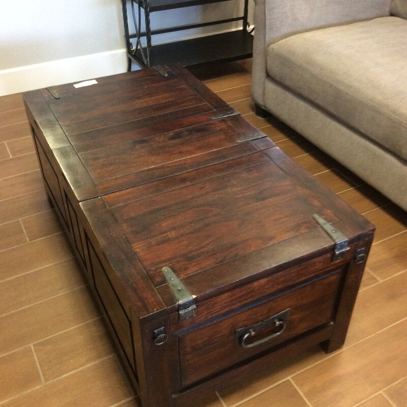 This trunk style Coffee Table has a dark wood stain finish with strap hinges and inside storage.