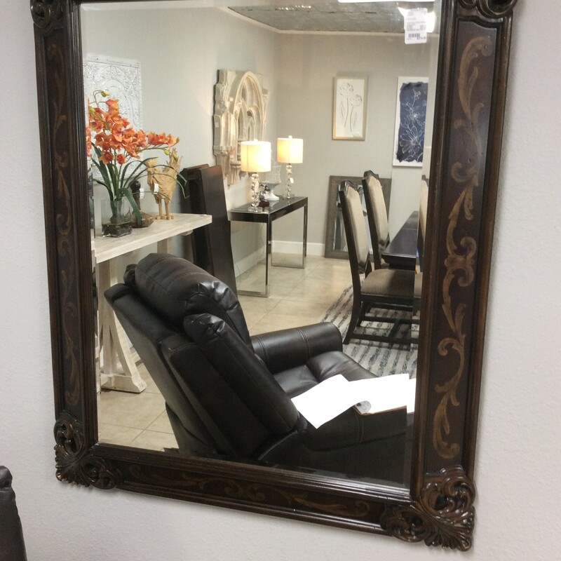 This beveled Mirror has a wooden frame with gold painted details and cerved corners