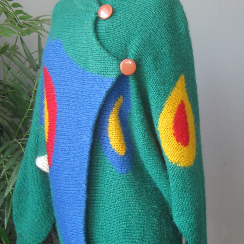 Dramatic and sophisticated colorblock cardigan sweater from Excel.<br />
Batwing sleeves, funnel neck<br />
Buttons somewhat asymmetrically at the top and bottom<br />
Surreal-esqe round shapes on the front sleeves and back in red, yellow, white and blue<br />
50% acrylic, 35% mohair, 15% nylon<br />
Excellent condition, no flaws<br />
Made in Hong Kong<br />
Marked Size 1, i don't know what that means but this sweater will fit a modern medium to large size person<br />
Here are the flat measurements, please double where appropriate:<br />
Armpit to armpit: 22 aprox.<br />
width at hem: 18 stretches comfortably to 21<br />
Length: 28.25, you can wear it bloused over at the waist if you button the bottom button.<br />
<br />
Thanks for looking!<br />
#76253