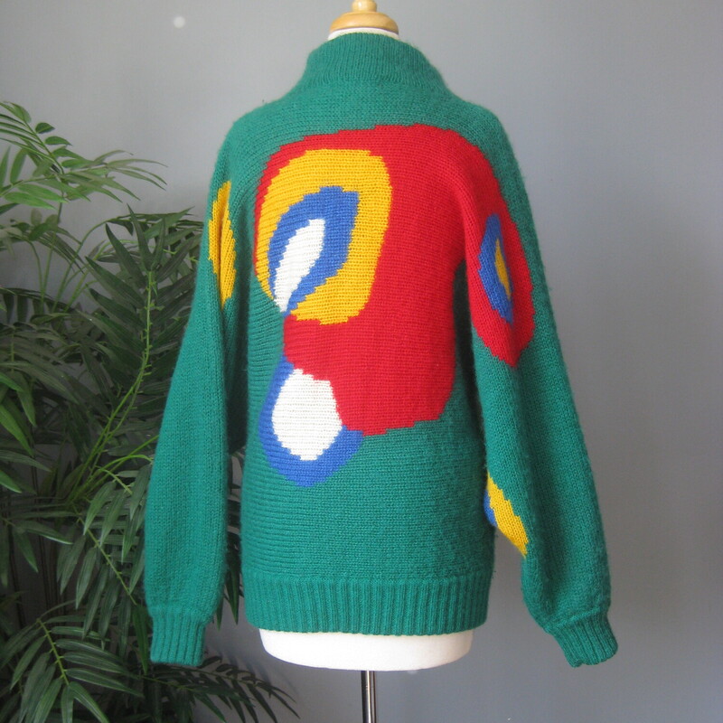 Dramatic and sophisticated colorblock cardigan sweater from Excel.<br />
Batwing sleeves, funnel neck<br />
Buttons somewhat asymmetrically at the top and bottom<br />
Surreal-esqe round shapes on the front sleeves and back in red, yellow, white and blue<br />
50% acrylic, 35% mohair, 15% nylon<br />
Excellent condition, no flaws<br />
Made in Hong Kong<br />
Marked Size 1, i don't know what that means but this sweater will fit a modern medium to large size person<br />
Here are the flat measurements, please double where appropriate:<br />
Armpit to armpit: 22 aprox.<br />
width at hem: 18 stretches comfortably to 21<br />
Length: 28.25, you can wear it bloused over at the waist if you button the bottom button.<br />
<br />
Thanks for looking!<br />
#76253