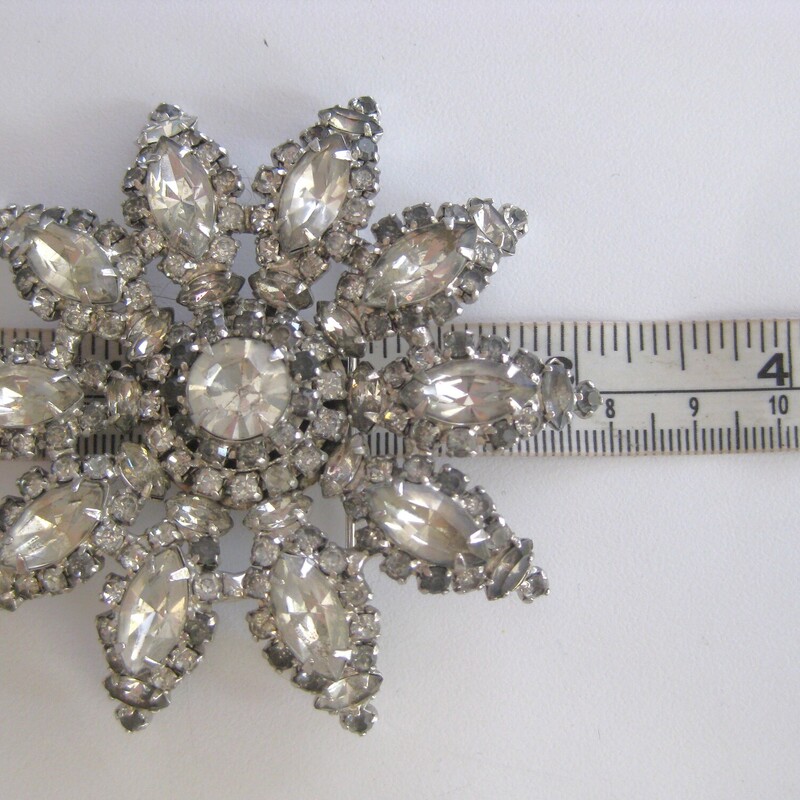 Rhinestone Brooch, Silver/C, Size: XL<br />
Stylized floral design done in various size and shapes of clear rhinestones set in silver metal.<br />
This pin is quite large 3 in diamter<br />
Excellent condition but VERY old and the stones have some cloudiness.<br />
Still it makes a impressive elegant statement when pinned on a black coat.<br />
No markings.<br />
Thanks for looking!<br />
#73829