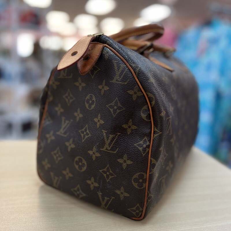 Louis Vuitton Monogram Speedy 35 Top Handle Handbag<br />
SD1913 -The date code indicates a production date of: November 1993 in France.<br />
Introduced in 1930, the Louis Vuitton Speedy bag was crafted to meet the fast-paced lifestyle of its time. Originally designed as a travel companion, the bag's name reflects its swift adaptability to the needs of the modern traveler.<br />
The top handle bag continues to be used in top high end fashion.  This bag (This is NONE strap version) is from 1993 and is still in fine shape.    However, please expect normal wear.<br />
-Brown Coated Canvas<br />
-LV Monogram Printed<br />
-Brass Hardware<br />
-Leather Trim<br />
-Rolled Handles<br />
-Canvas Lining & Single Interior Pocket<br />
-Zip Closure at Top<br />
-Handle Drop: 3\"<br />
-Height: 10.25\"<br />
-Width: 12.25\"<br />
-Depth: 6.75\"<br />
The interior of this bag is very clean, the exterior coated canvas is also in great shape with no marks or stains.  The most worn areas on the bag is the tanning to the leather and from over 30 years of use.  The leather zipper pull is the only piece fairly new, replaced by the consignor through LV.  It is in fine shape and a wonderful addition to a LV collector or someone who would like to invest in a vintage LV.<br />
These bags retail around 1550 from LV Brand New.