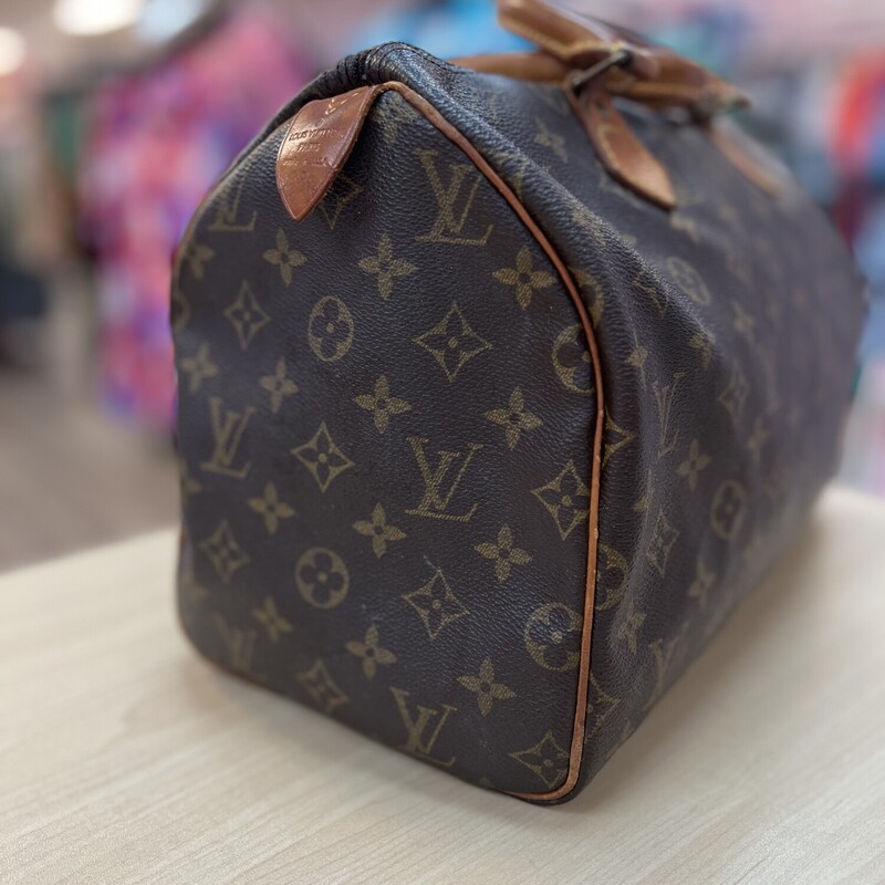 Louis Vuitton Monogram Speedy 35 Top Handle Handbag<br />
SD1913 -The date code indicates a production date of: November 1993 in France.<br />
Introduced in 1930, the Louis Vuitton Speedy bag was crafted to meet the fast-paced lifestyle of its time. Originally designed as a travel companion, the bag's name reflects its swift adaptability to the needs of the modern traveler.<br />
The top handle bag continues to be used in top high end fashion.  This bag (This is NONE strap version) is from 1993 and is still in fine shape.    However, please expect normal wear.<br />
-Brown Coated Canvas<br />
-LV Monogram Printed<br />
-Brass Hardware<br />
-Leather Trim<br />
-Rolled Handles<br />
-Canvas Lining & Single Interior Pocket<br />
-Zip Closure at Top<br />
-Handle Drop: 3\"<br />
-Height: 10.25\"<br />
-Width: 12.25\"<br />
-Depth: 6.75\"<br />
The interior of this bag is very clean, the exterior coated canvas is also in great shape with no marks or stains.  The most worn areas on the bag is the tanning to the leather and from over 30 years of use.  The leather zipper pull is the only piece fairly new, replaced by the consignor through LV.  It is in fine shape and a wonderful addition to a LV collector or someone who would like to invest in a vintage LV.<br />
These bags retail around 1550 from LV Brand New.