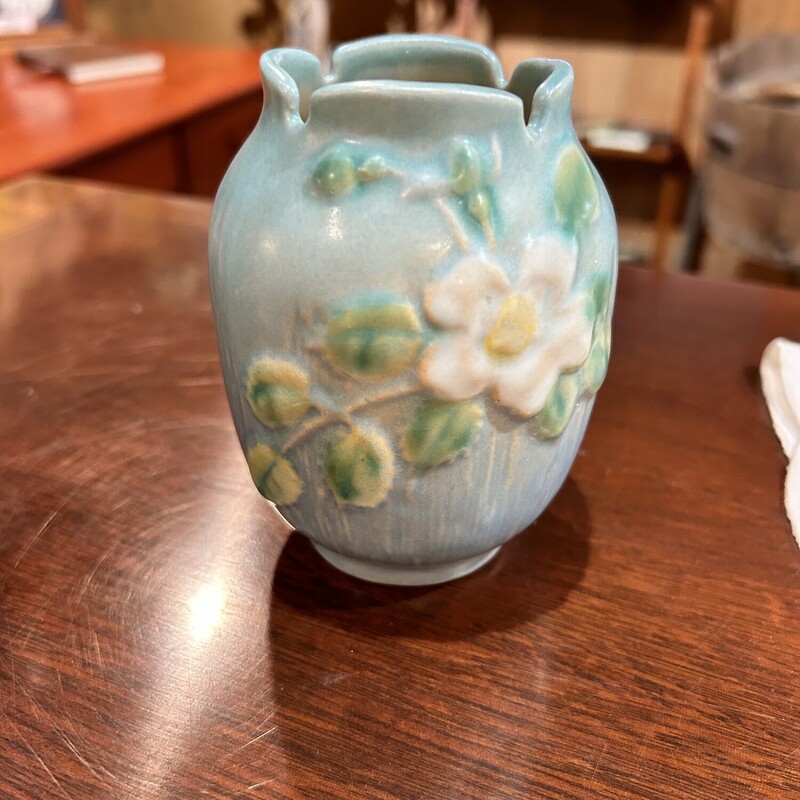 Roseville Blue Jardiniere,<br />
 Size: 4 1/4<br />
This blue vase was made in the 40s by Roseville - 978-4 and has a white rose on each side.  It is in very good condition.