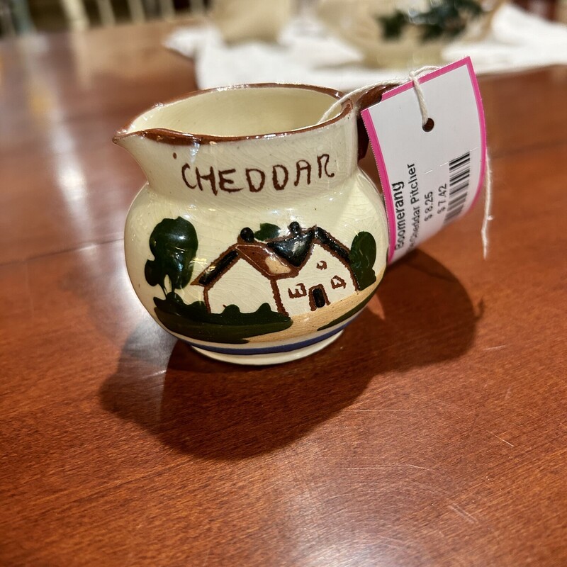 Watcombe Cheddar Pitcher
Size: 2 In T
Watcombe Tourquay creamer.  One side has a cottage with the word Cheddar and the other side says Fresh From The Cow.  There are three pieces available - all sold sepqrately.
