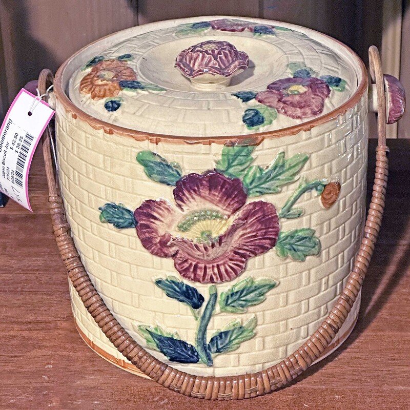 Japan Biscuit Jar,
 Size: 8x7
This biscuit jar was made in Japan. It is a pale yellow color with red/orange flowers. There is a rattan handle and a small chip in the lid, otherwise it is in great condition
