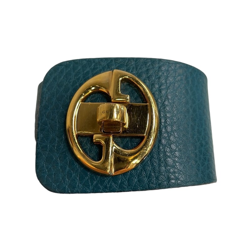 Gucci Vintage Turn Key Bracelet<br />
<br />
Made in Italy by Gucci. This gold tone turnkey style leather cuff bracelet is still in good condition.<br />
The bracelet flares from just under 2 inches at the widest point down to 1 1/2 inches at the back.<br />
The turnkey clasp makes this bracelet easy to put on and to take off.<br />
The clasp bears the name GUCCI prominently shown.<br />
The embossed, leather front is in teal color and the reverse side and edges are in black leather.<br />
Total length when fully extended is 9 inches.<br />
<br />
Recommended for anyone with a 6.5 inch wrist circumference or smaller due to placement of closure.<br />
<br />
Please Note: the inner side of the hardware is missing one of its two screws. However, the bracelet is still fully functional. Hardware has some light scratches. See photos for reference.