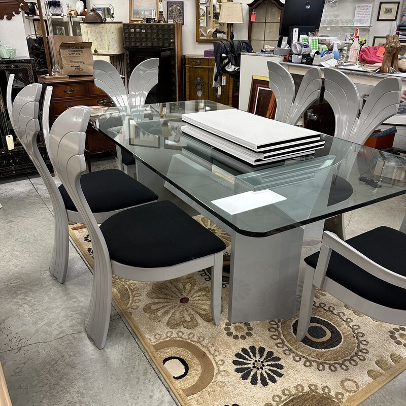 Beautiful Art Deco Dining Room Set, in excellent condition and appears to have been rarely used. The glass-top dining table measures 79x42in and the heavy glass is about an inch thick. Includes six upholstered shell-back chairs, also in great condition. Set is in a slate gray finish, and table pads are included.