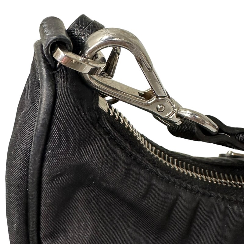 Prada Re Edition Nylon 2005 Black Crossbody<br />
<br />
Dimensions:<br />
Height: 18cm<br />
Width: 22cm<br />
Length: 6cm<br />
<br />
Factory Code: 7/D<br />
<br />
Note: small rip on inteior by the tag, does not come with small pouch.